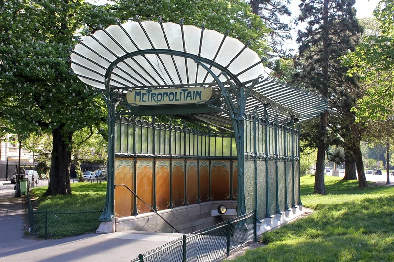 Lối vào ga tàu điện ngầm Metropolitain theo kiểu Art Nouveau với mái kính nằm giữa công viên ở Paris.
