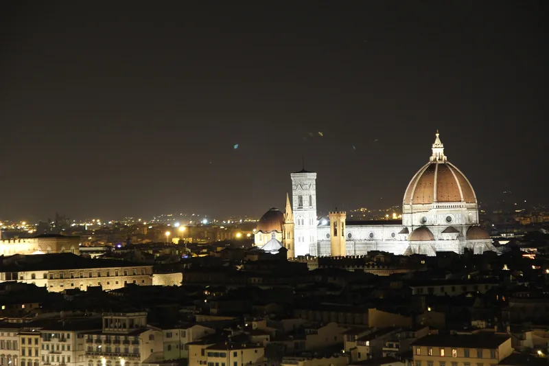 Mái vòm và tháp chuông của Nhà thờ Florence sáng rực giữa đường chân trời thành phố về đêm.