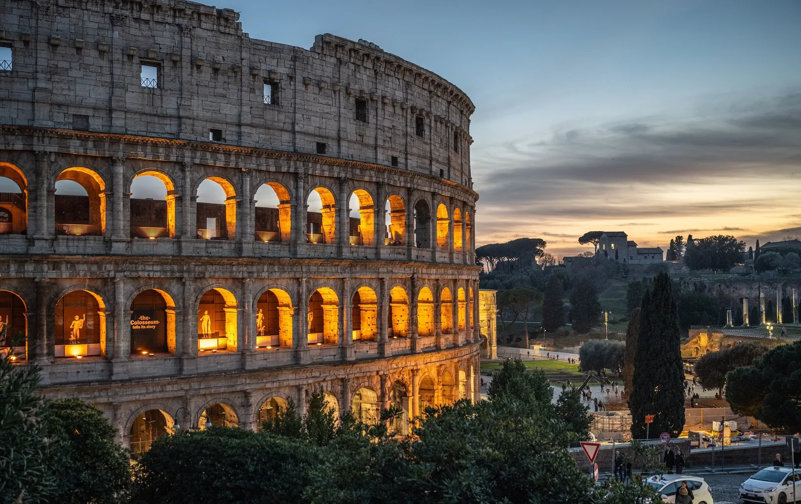 Những mái vòm của đấu trường Colosseum sáng đèn rực rỡ dưới hoàng hôn ở Rome.