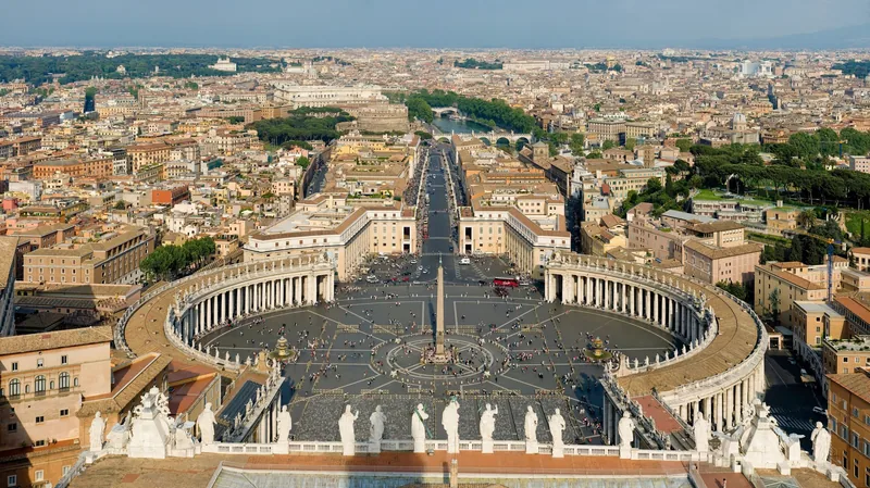 Toàn cảnh từ trên cao Quảng trường Thánh Phêrô với hàng cột và tháp bút, phía xa là thành phố Rome.