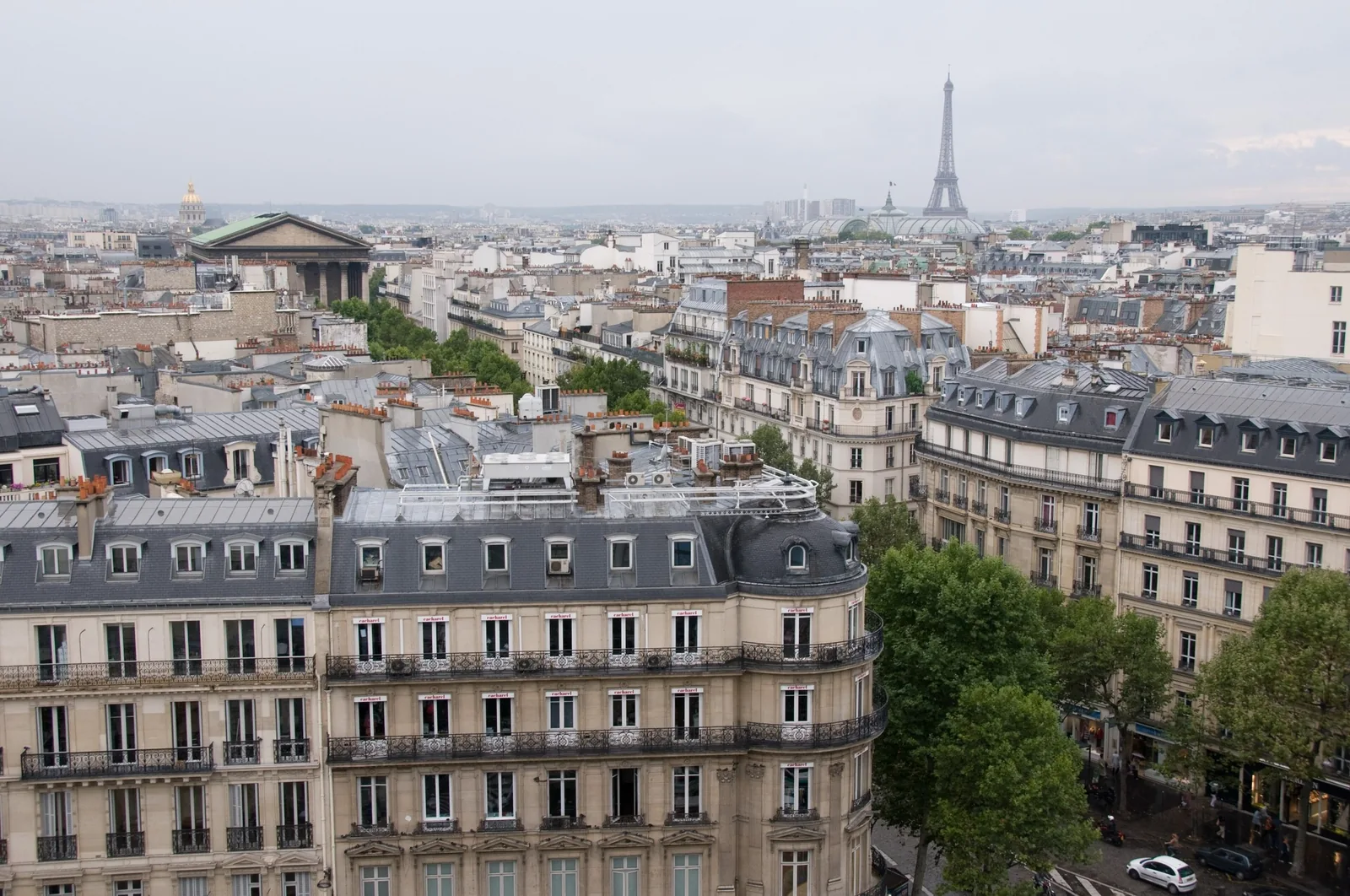 Toàn cảnh mái nhà Paris nhìn từ trên cao với tháp Eiffel thấp thoáng phía xa.