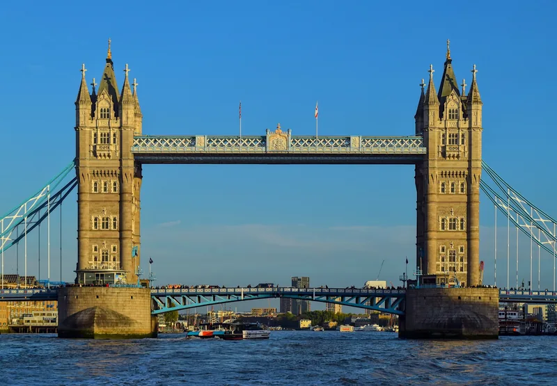 Hai tháp đá của cầu Tower Bridge vươn cao bên sông Thames ở London dưới bầu trời xanh trong.