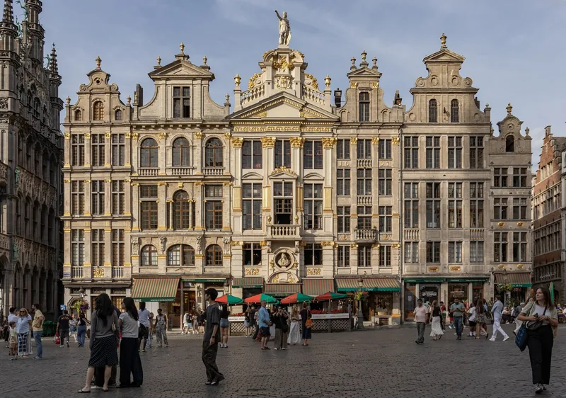 Dãy nhà phường hội theo phong cách baroque dát vàng bao quanh Grand Place ở Brussels, du khách dạo bước trên quảng trường.