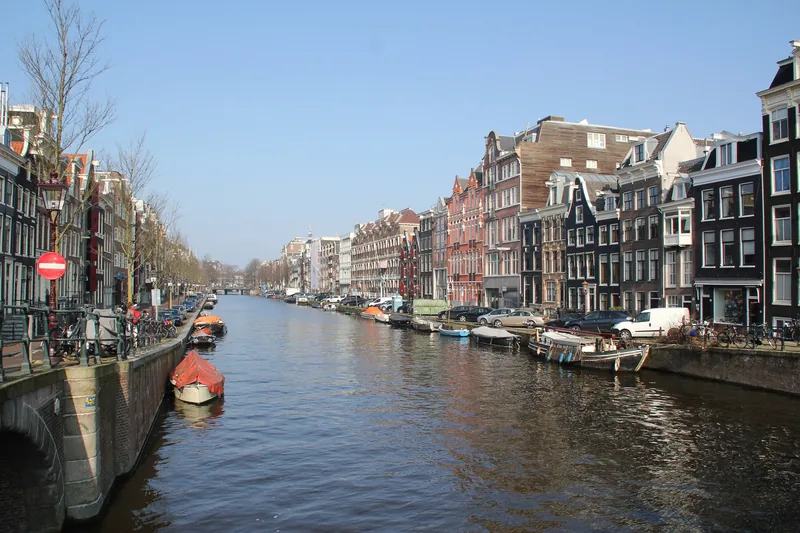 Những ngôi nhà mái nhọn cổ kính nằm dọc kênh đào yên tĩnh với thuyền neo đậu ở Amsterdam, Hà Lan.