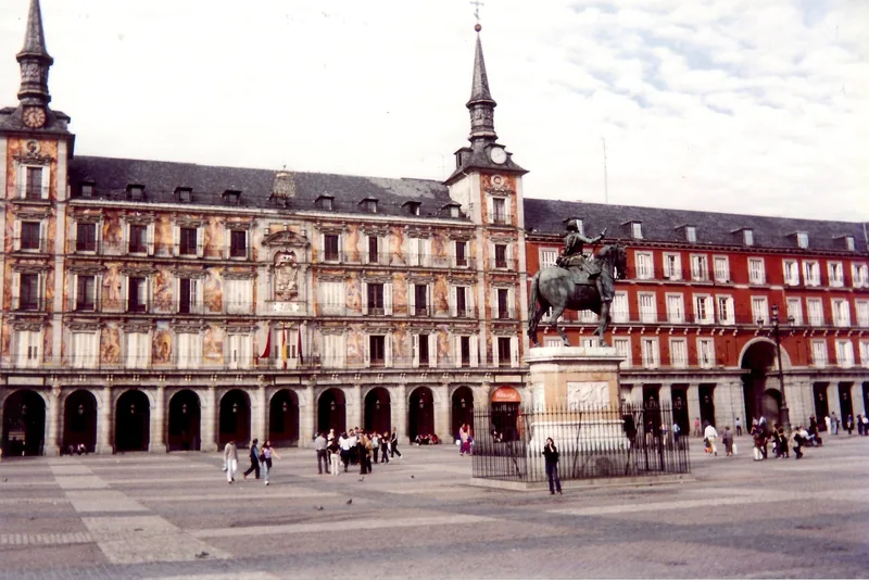 Tượng kỵ sĩ đứng trước mặt tiền vẽ tranh lịch sử của Plaza Mayor ở Madrid.